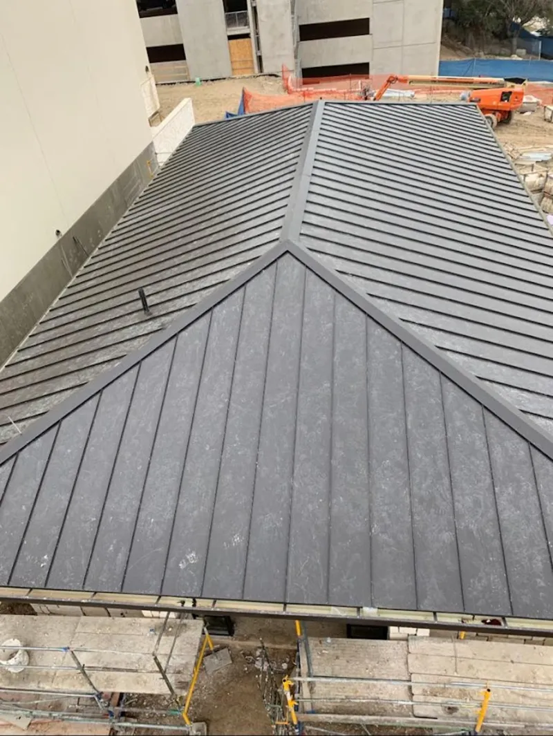 Commercial metal roof construction with crane equipment in Wheeling